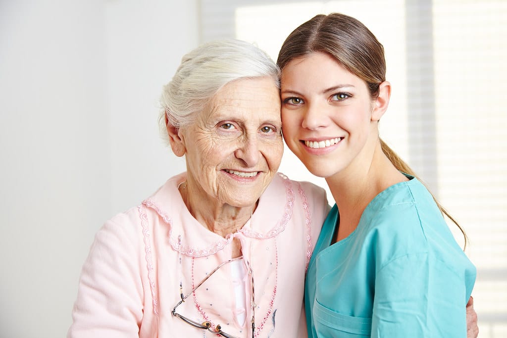Smiling caregiver sharing a joyful moment with an elderly woman